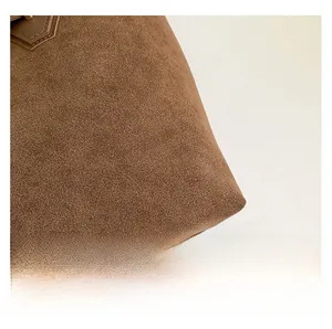 Detail view of premium dark brown suede tote bag featuring high-quality reinforced stitching