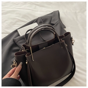 Close-up of deep brown litchi pattern leather tote with golden metal hardware