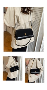 Detail of elegant black leather crossbody bag with gold rotating clasp and chain strap