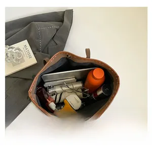 Macro view of brown tote bag interior capacity showing tablet and daily essentials