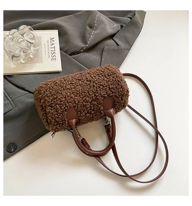 Gros plan détaillé sur la texture en polaire marron foncé et les poignées en cuir du sac