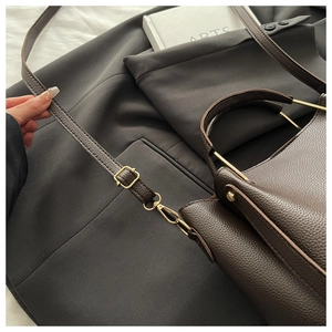 Detail of dark brown lychee leather bag with gold metal hardware and adjustable strap