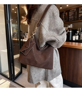 Detail of vintage dark brown pebble leather tote bag with matching envelope pouch