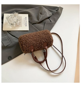 Vue détaillée du sac polochon marron en peluche avec poignées en cuir et garnitures argentées