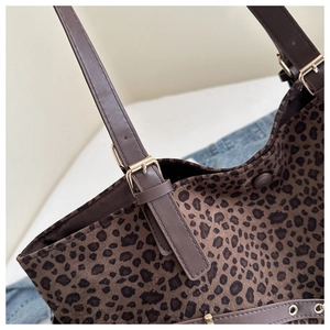 Detail of leopard print tote bag with brown leather strap and golden buckle adjustment