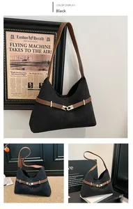 Detail view of black suede tote bag with brown contrast straps and gold metal buckle