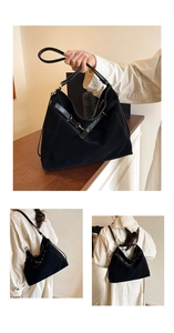Close-up of black matte suede hobo bag with leather straps and metallic buckle detail