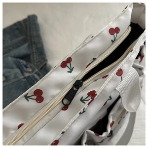 Detail of smooth black zipper and white cherry print on waterproof nylon tote bag