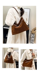 Detail view of large brown suede tote bag with decorative metal eyelets and adjustable strap