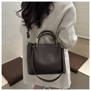 Dettaglio della borsa tote in pelle marrone scuro con trama e fibbia in metallo regolabile