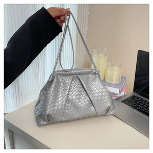 Detail of silver woven shell bag with pleated metallic texture and slim shoulder strap