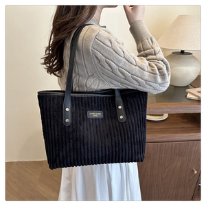 Détail du sac cabas en velours côtelé noir avec texture côtelée et anses en cuir