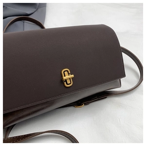 Close-up of vintage dark chocolate leather bag with a gold C-shaped rotating metal lock