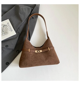 Detailed macro view of dark brown suede tote with gold interlocking buckle and matte texture