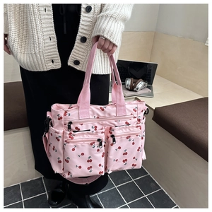 Pink canvas tote bag with cherry print featuring multiple functional zip pockets and straps