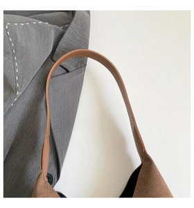 Detail of premium brown suede tote bag featuring leather shoulder strap and quality stitching