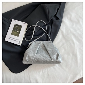 Detailed view of silver woven shell bag with pleated texture and thin shoulder strap