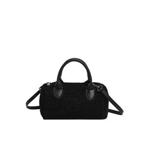 Retro black faux shearling cylinder bag with leather handles and silver zipper detail