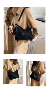 Close-up of black matte leather shoulder bag with gold lettering and small envelope charm