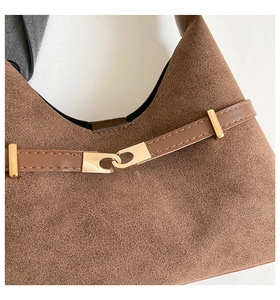 Detail of brown suede tote bag with golden metal buckle and smooth leather strap