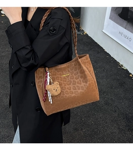 Dettaglio borsa tote leopardata con tracolla intrecciata e ciondolo orso