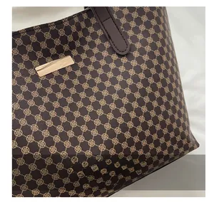 Macro shot of dark brown tote bag fabric with clover print and metallic logo plate