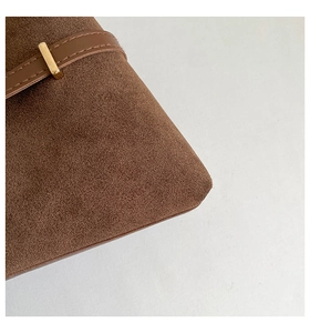 Detail of brown suede tote bag featuring a minimalist gold rectangular metal buckle