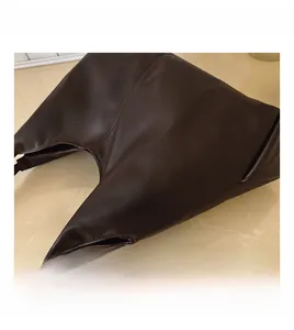 Detailed close-up of dark brown soft leather tote bag showing fine texture and stitching