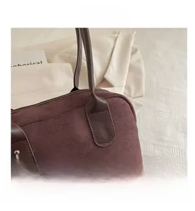 Detailed close-up of dark red suede bowling bag with premium silver metal hooks and hardware