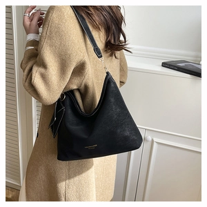 Detail of black faux leather tote with gold FASHION & BAGS lettering and white stitching