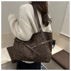 Detail of leopard print tote bag featuring brown PU straps and metallic gold hardware