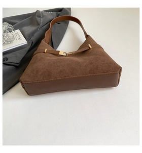 Detail of vintage brown suede tote bag featuring smooth leather trim and gold metal buckle