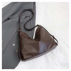 Détail du sac cabas souple en PU mat marron foncé sur fond blanc avec blazer gris