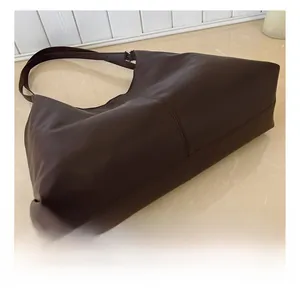 Close-up of precise double stitching on the side and base of a matte brown tote bag