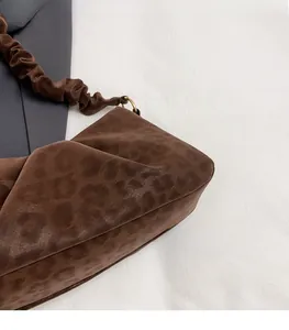 Detail of leopard print cloud bag featuring pleated strap and gold hardware rings