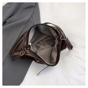 Vue détaillée de l'intérieur d'un grand sac en cuir marron avec doublure grise et métal doré