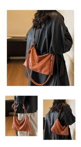 Detail of caramel brown faux leather tote with decorative knot and patterned strap