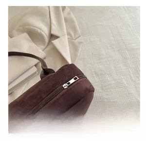 Close-up of a smooth silver metal zipper on a dark brown vintage suede Boston bag detail