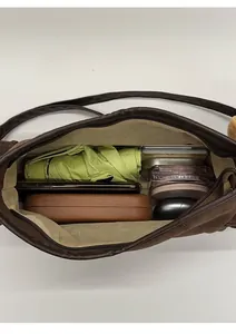 Interior view showing large capacity and storage compartments of the brown crossbody bag