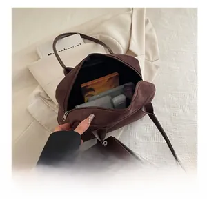 Macro detail of the spacious interior of a dark brown suede tote bag with accessories