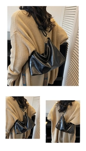 Detail of black glossy leather tote bag showing soft creases and golden ring hardware