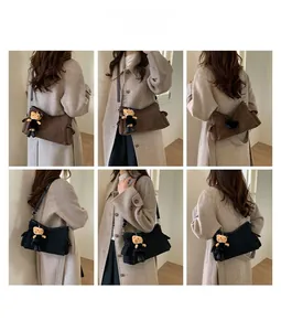 Lifestyle view showing two minimalist crossbody bags in black and brown with cat charms