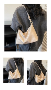 Detail of beige hobo bag with knotted rope strap and bohemian embroidered wide strap