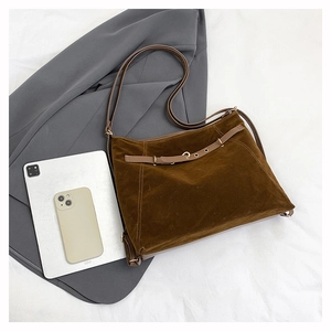 Vue détaillée du sac cabas en daim marron avec bandoulière en cuir et boucle en métal