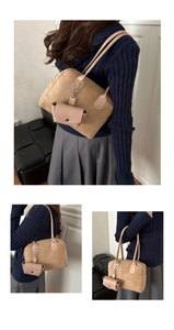 Detailed view of khaki suede baguette bag with matching shoulder strap and mini pouch charm