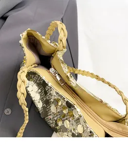 Dettaglio della cerniera in metallo e paillettes dorate sulla borsa a tracolla moda