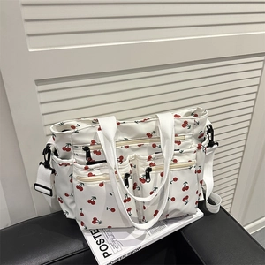 Large white tote bag with red cherry print, featuring multiple utility pockets and strap