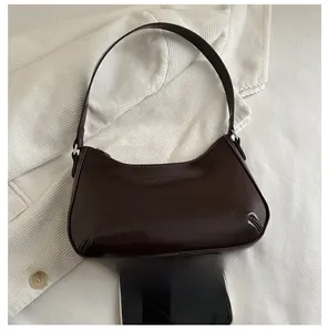 Detail showing deep brown saddle bag size compared to a smartphone on velvet background