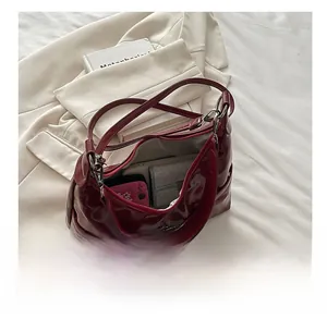 Interior view of spacious dark red patent leather shoulder bag with multiple items
