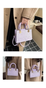 Detail of lavender star pattern bag with woven handle and gold hardware accents